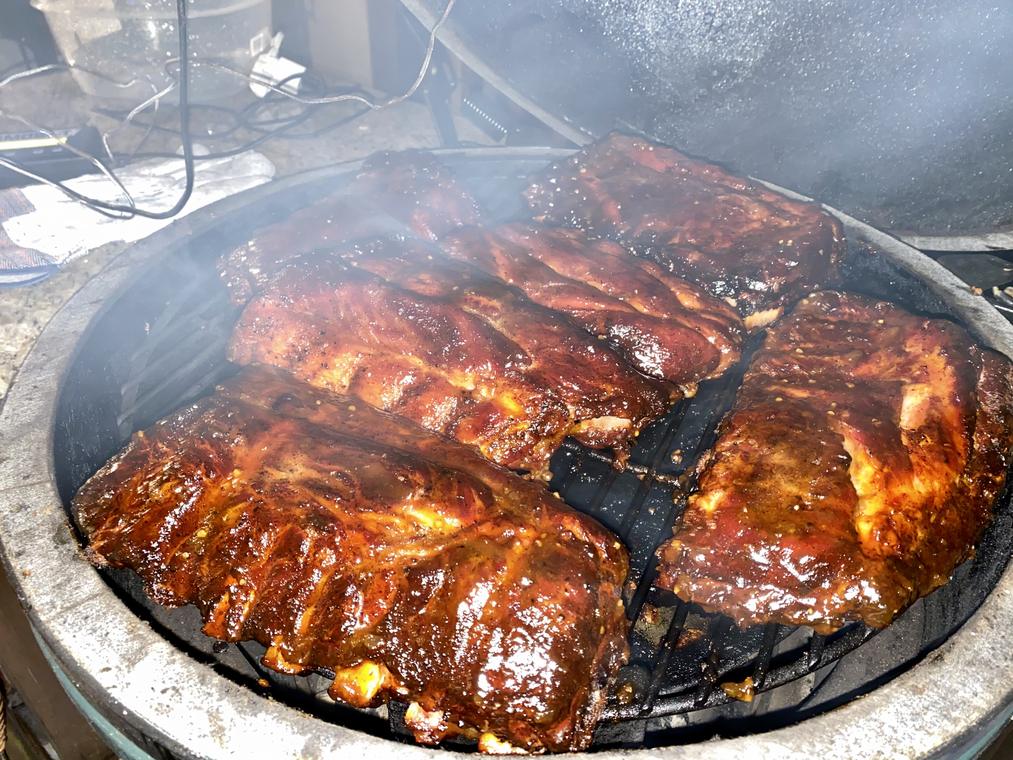Racks of ribs under heavy smoke on the kamado