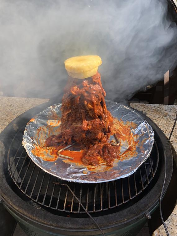 A glowing chimney and a cloud of smoke off the kamado