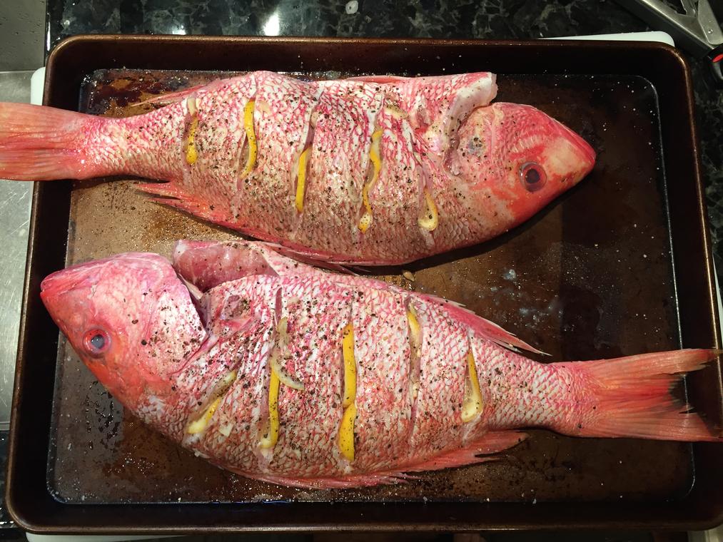 Two whole red snapper, scored and stuffed with lemon