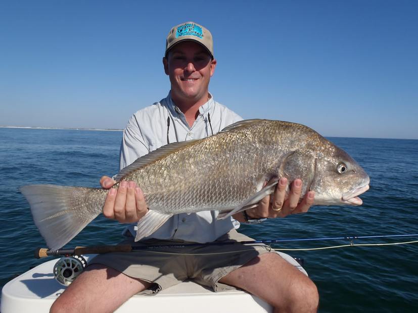 A big black drum held across both arms