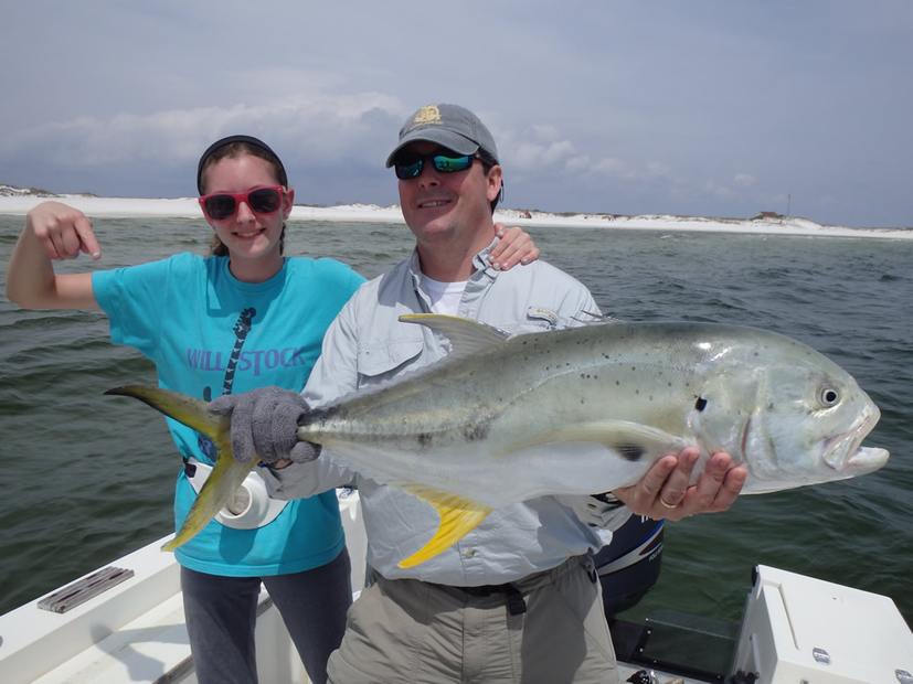Two anglers holding an amberjack on the flats