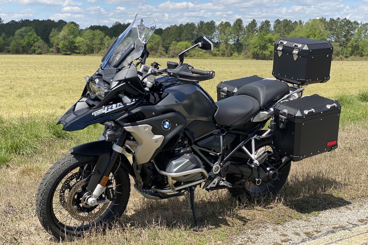 The BMW R 1250 GS loaded with panniers, parked in an open field