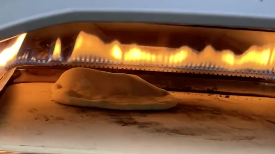 A pita ballooning on the stone inside the Ooni, flames raking across the roof of the oven